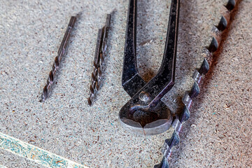 Wall Mural - black and metal cutting pliers for working with metal, a pair of drills close-up lies on a wooden desktop