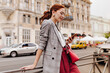© Look! - Red haired woman in stylish outfit chatting on phone