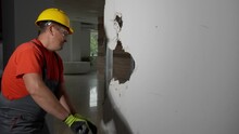 Male Builder Breaking Gypsum Board Wall Indoors