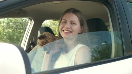 Wall Mural - Beautiful woman with cute dog sitting in modern car