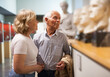 © JackF - Positive couple of pensioners standing at hall of museum and looking at exhibits