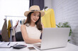© PBXStudio - Young Asian woman selling clothes online, she is chatting and answering customer questions on social media.
