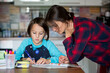 © Tomsickova - Mother, helping her child with homeworks, kid learning at home during pandemic Covid lockdown