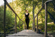 © Ahmed - Attractive hot woman standing on footbridge in forest