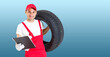 © Angelov - car mechanic carrying tire on blue background. happy man smiling amd looking into camera