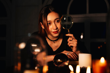 Beautiful young long hair woman fortune teller in dark room.