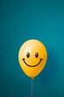 Leinwandbild Motiv Stock photo of a yellow balloon with smiley face on a blue background