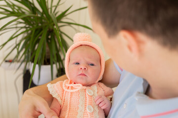 Woman and man giving a newborn baby. Mom, dad and baby. Close-up. Portrait of a young smiling family with a newborn baby in their arms. Happy family on the background.