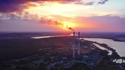 Wall Mural - Pipes with chemical smoke of industrial plant. Panoramic view of factory surrounded by beautiful nature in the evening. Air pollution. Aerial view.