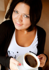 Wall Mural - young woman sitting in a cafe drinking coffee