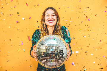 Wall Mural - Happy fashion girl holding disco ball with confetti around the scene - Party, event and celebration concept - Focus on face