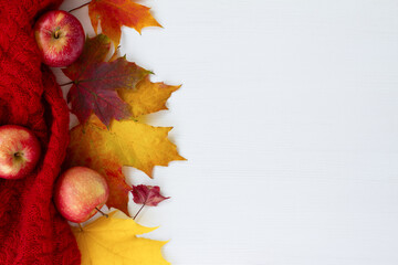 Wall Mural - White wooden background. Autumn yellow and red leaves. Apples. Red scarf