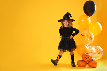 Canvas Print - Cute little girl with pumpkins and balloons wearing Halloween costume on yellow background. Space for text