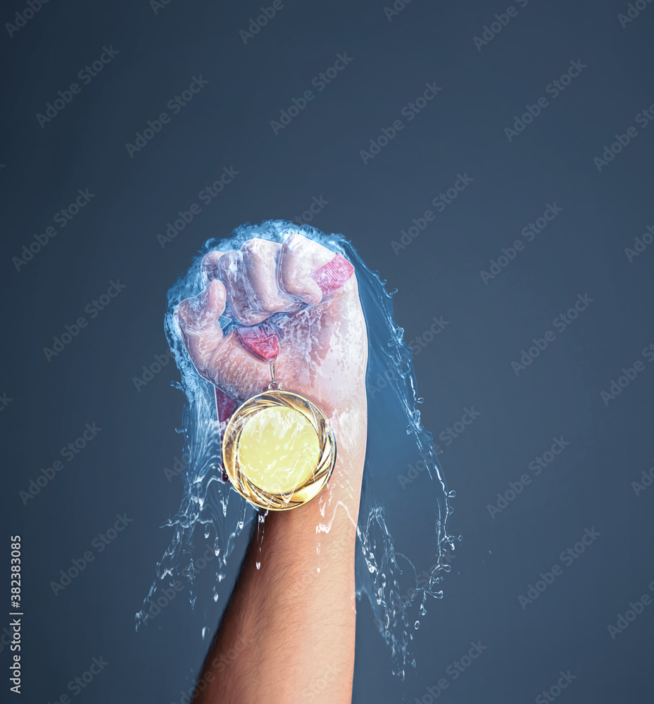 Winner raising hand with gold medal through water splash on dark grey background, closeup - obrazy, fototapety, plakaty 