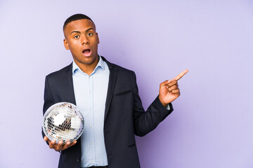 Wall Mural - Young latin man holding a ball party isolated pointing to the side