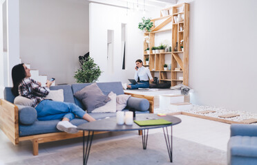 Female friends resting in light modern apartment