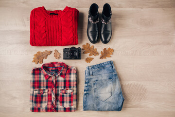 flat lay of woman style and accessories, red knitted sweater, checkered shirt, denim jeans, black leather boots, autumn fashion trend, view from above, vintage photo camera, traveler outfit