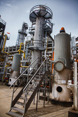 Oil refinery and gas processing plant. Grey metal distillation towers (distillery column), tanks and pipelines. Blue sky.