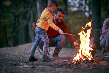 Wall Mural - Father and son starting a fire; Quality family time concept