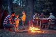 © luckybusiness - Family camping in the woods; Spring or autumn camping with campfire at night ; camping, travel, tourism, hike and people concept. Quality family time together.