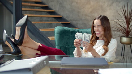 Joyful business lady counting money in office. Woman jackpot winner.