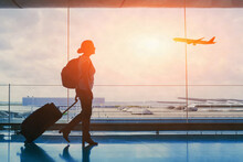 Tourist Travel To International Airport Terminal, Silhouette Of Woman Passenger With Luggage Suitcase