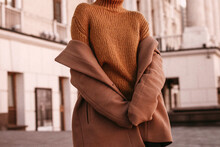 Young Woman With Cropped Face In The Orange Knitted Sweater And Brown Coat, Outdoor Portrait In Daylight. Cozy Autumn. 