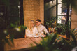 © Elizaveta - Happy Couple Meeting And Drinking Coffee. love and romantic date in downtown cafe restaurant. Young happy couple in love in cafe. Young couple date in cafe, talking and kissing at Christmas time