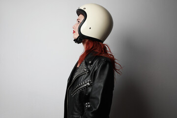side view portrait of young woman with a motorcycle helmet posing over isolated white background cel