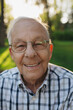 © Rob and Julia Campbell/Stocksy - Happy, smiling portrait of senior man outside