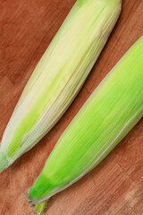 Wall Mural - green corn cobs fresh whole whole lie on the table