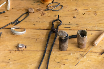 Set work tool of a master jeweler, container for metal casting, tongs. selective focus