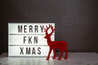 © Gillian Vann/Stocksy - light box with the message Merry Fkn Xmas