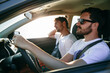 © AlejandroMCB photo & film/Stocksy - Young male friends driving a car during a road trip travel at sunset