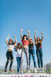 © MyMicrostock/Stocksy - Group of five teens jumping against a blue sky