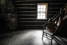 Empty Room With Single Chair. Sunlight Streams Through The Window Of A Cabin With An Empty Wooden Chair In The Corner. This Is A State Owned Historical Building And Not A Private Property.