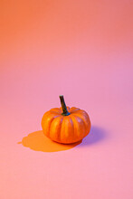Creative Layout Made With Neon Pumpkin With Orange Shadow On Pink. Minimal Halloween Pumpkin Background Concept.