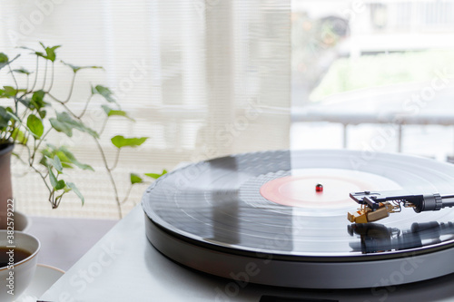 Fotografía 陽が射し込む窓辺のレコードプレイヤーで趣味の音楽を聴く