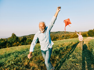 Wall Mural - woman man outdoor senior couple happy lifestyle retirement together smiling love kite run nature mat