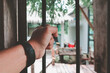© D.APIWAT - Man's hand is holding iron bar of window in the day of confinement in house.