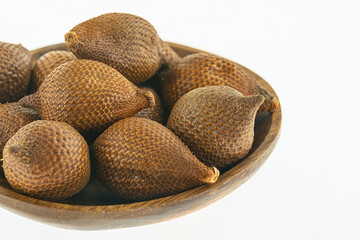 Wall Mural - bamboo plate full of dark brown snake fruit stands on a white background