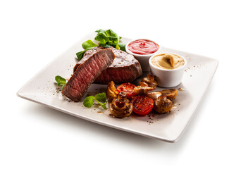 Barbecue beef steak with fresh tomatoes, champignons, mustard and ketchup on white background
