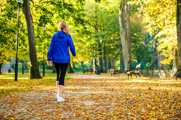 Wall Mural - middle-aged woman walking in city park