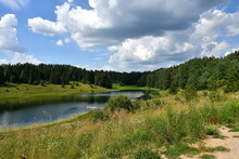 View Of A Small Beach With A Wooden Pier Or Jetty Located Next To A Shallow River Or Lake Covered From Both Sides With Dense Shrubs, Forests And Moors Spotted On A Sunny Summer Day In Poland