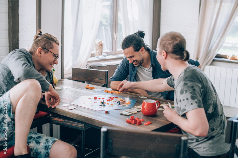 Friends play a board game in the living room Stock Photo | Adobe Stock