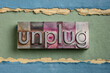 © MarekPhotoDesign.com - unplug  - lifestyle or information overload concept  - word in vintage gritty letterpress metal type against colorful handmade paper