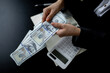 © David - Closeup of business woman hands counting US dollar cash on the table.people holding Us dollar banknotes money ,using calculator calculate saving money with happy in office.