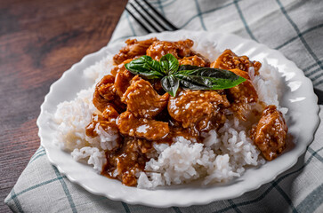 Wall Mural - Chicken Breast with sauce and Rice in white plate on a wooden table background