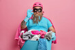 © wayhome.studio  - Satisfied busy bearded male housekeeper does laundry at home wears superhero costume wears rubber gloves isolated on pink background poses with basin and cleaning detergents. Housework concept