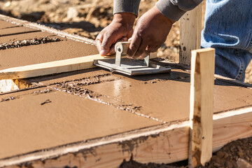 Wall Mural - Construction Worker Using Hand Groover On Wet Cement Forming Coping Around New Pool